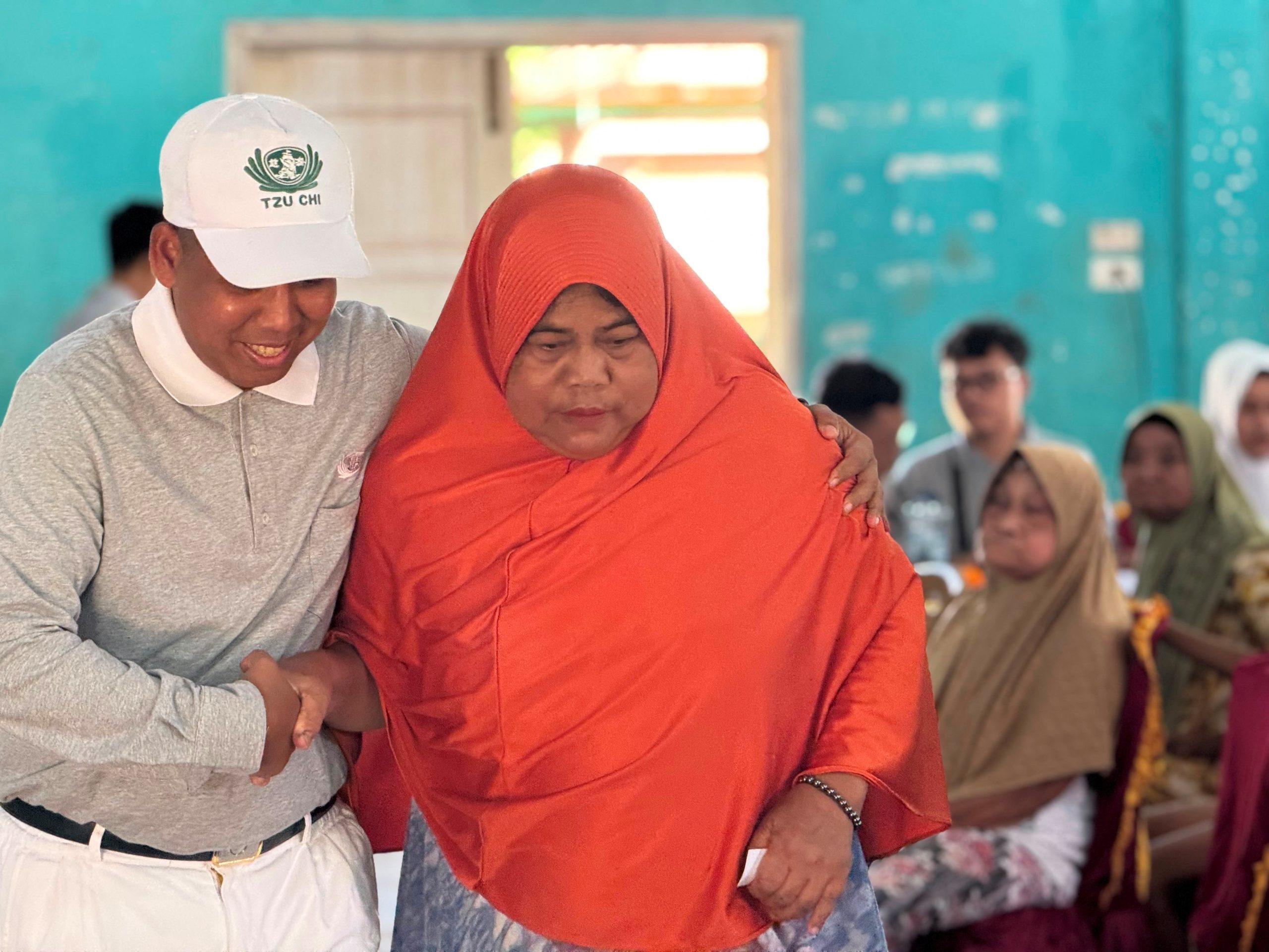 Relawan dan tenaga medis membantu seorang lansia